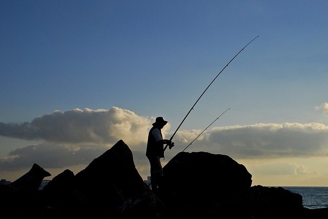 A person fishing near sunset.