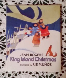 The cover of King Island Christmas shows Native Alaskan children whistling to make the Northern Lights dance