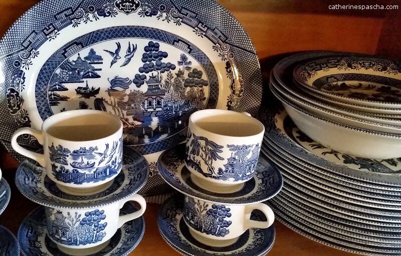 Blue willow cups and saucers, plates and bowls, and platter, all ready to be used for Thanksgiving dinner.