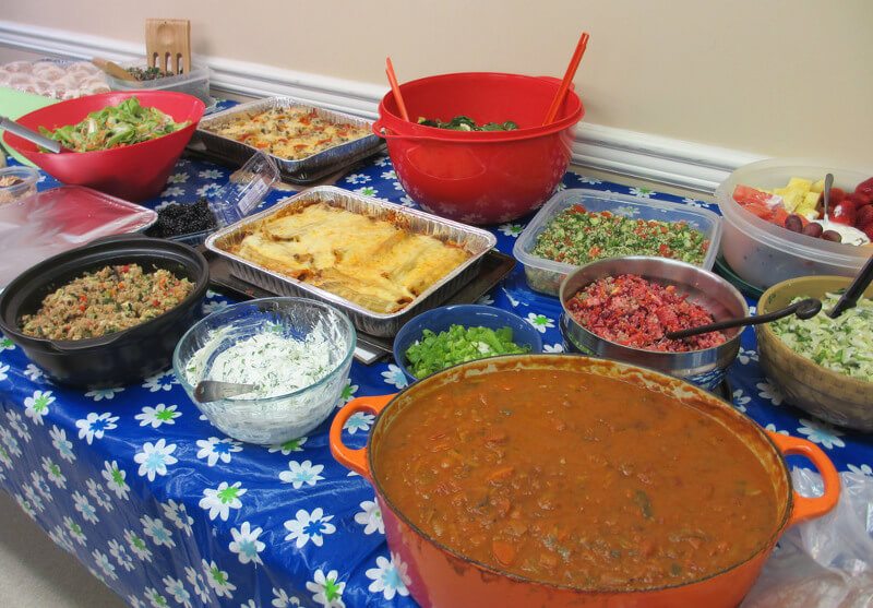 Table at a church potluck, with chile, casseroles, and salads.