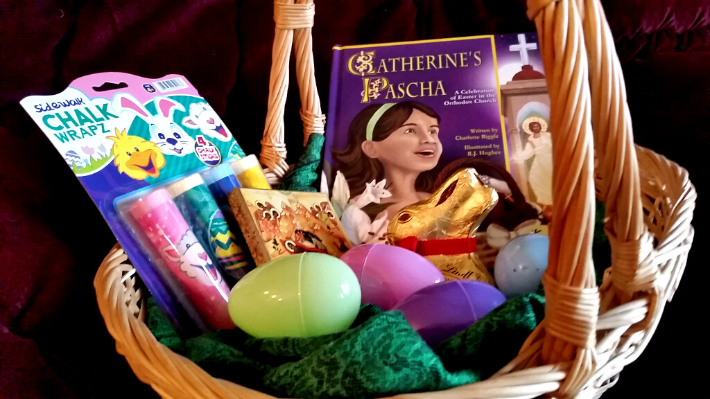 Pascha basket with Catherine's Pascha, sidewalk chalk, an icon of the Nativity, a chocolate bunny, and plastic eggs.