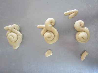 Pieces of dough being shaped into bunnies using the spiral method
