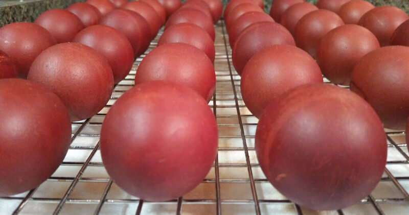 Red Pascha eggs drying on a metal rack