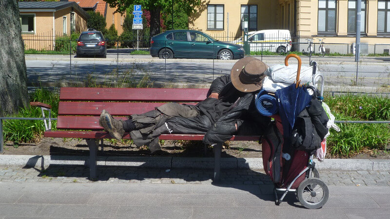homeless man asleep on a bench