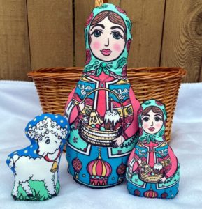 Large and small soft matryoshka dolls, with a stuffed lamb. 